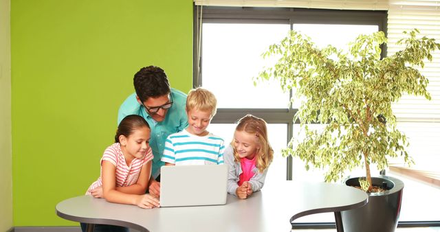 Male Teacher Engaging with Happy Children Learning on Laptop - Download Free Stock Images Pikwizard.com