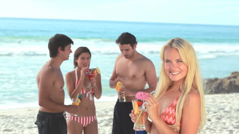 Group Enjoying Summer Beach Party with Colorful Cocktails