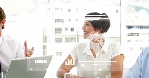 Smiling mature businesswoman listening in meeting interacting with digital hud graphics