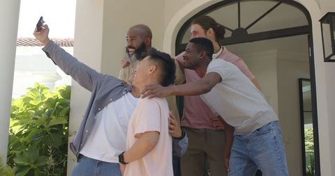 Diverse Group of Friends Taking Selfie Outside a Modern Home