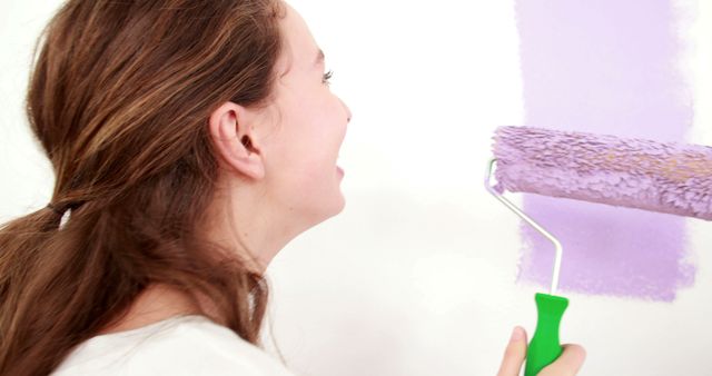 This image can be used for articles or advertisements about home improvement, DIY projects, house renovation, and interior decoration. It is ideal for demonstrating painting techniques or promoting painting supplies and services aimed at young adults or families.