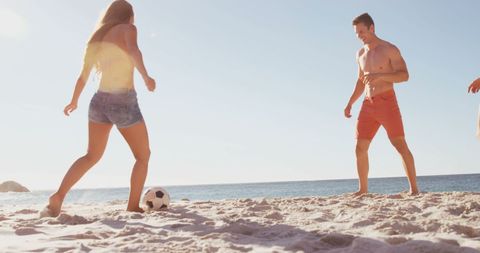 Friends Playing Soccer on Sunny Beach