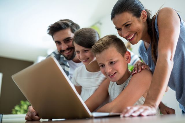 Happy family using laptop in the living room at home