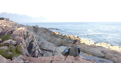 Woman Enjoying Ocean View While Hiking on Rocky Shore - Download Free Stock Images Pikwizard.com