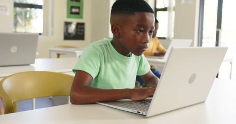 African American Boy Focusing on Laptop, Learning Coding and Digital Skills in Classroom