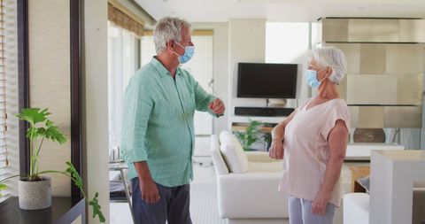 Senior Couple Greeting with Elbow Bump in Covid-safe Home Environment