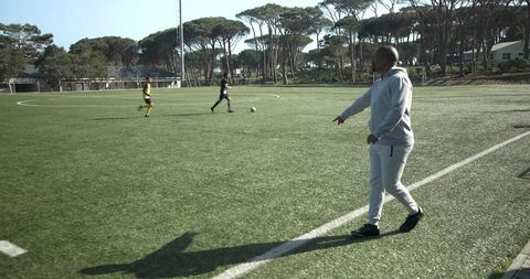 Soccer Coach Observing Team During Field Practice