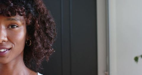 African american woman smiling headshot with natural light and minimalist background