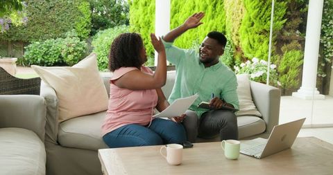 Happy Couple Gathering Outdoors with Laptop and Coffee