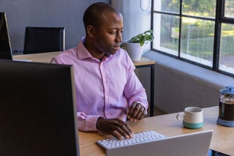 Businessman typing at desk in modern office