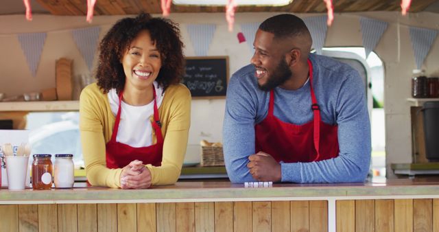 Portrait of african american couple wearing apron smiling while standing in the food truck - Download Free Stock Photos Pikwizard.com