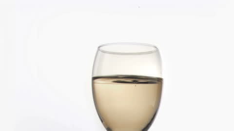 Slow Motion Drop Creating Ripples in Wine Glass