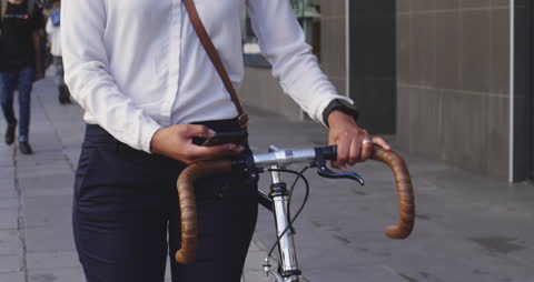 Urban Professional Walking Bicycle While Using Smartphone Outdoors
