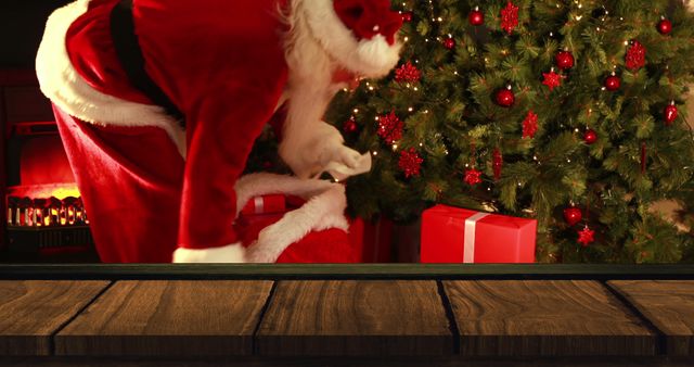 Santa Claus Placing Gifts by Christmas Tree with Fireplace in Background - Download Free Stock Images Pikwizard.com