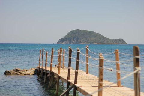 Tranquil Wooden Pier with Lush Green Island in Distance