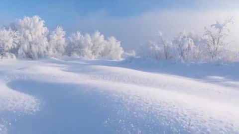 Gliding over frosted snow drifts revealing sparkling textured winter meadow under blue sky