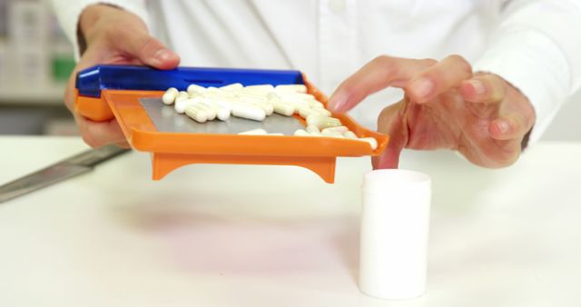 Pharmacist accurately counting tablets on a prescription tray, exemplifying professional pharmaceutical practices. Ideal for use in healthcare publications, pharmacy-related advertisements, and medical education materials.
