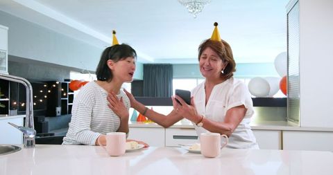 Senior Friends Celebrating Birthday with Cake and Coffee in Kitchen
