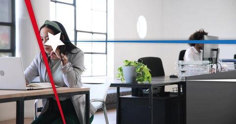 Working asian woman using laptop in open-plan office with biophilic minimalist design