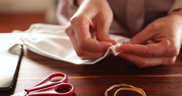 Hands Making Homemade Fabric Face Mask with Scissors and Rubber Bands - Download Free Stock Images Pikwizard.com