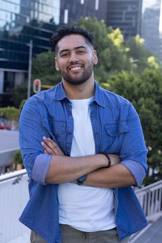 Confident african american man on urban overpass wearing denim shirt and watch