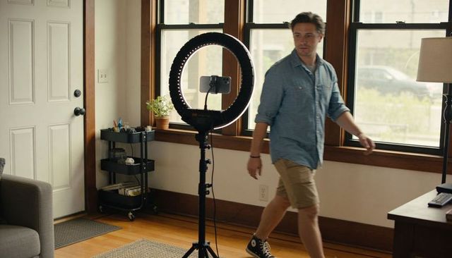 Content creator preparing home live stream with ring light and smartphone recording setup