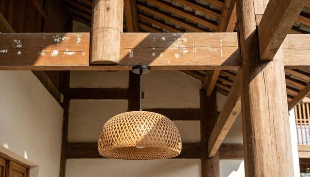 Hanging woven rattan pendant lamp casting lattice shadows under weathered timber beams