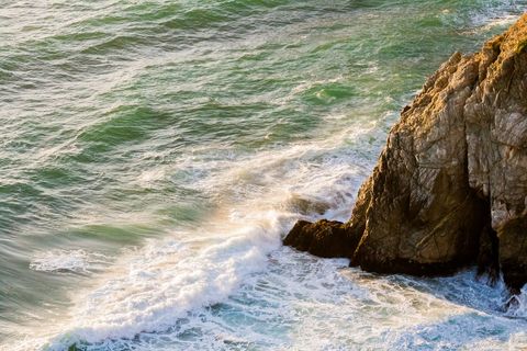Waves crashing on rocky coast at sunset
