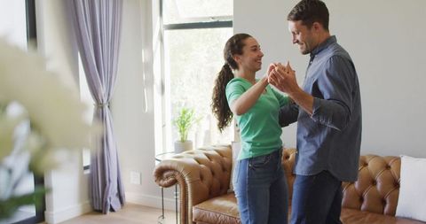 Young Couple Joyfully Dancing Together at Home