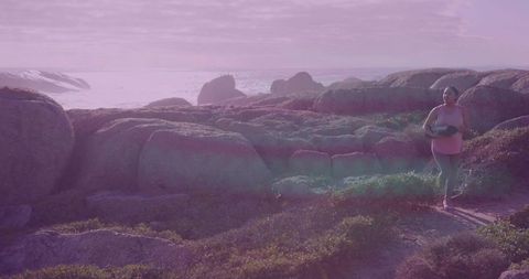 Indian woman walking with yoga mat along rugged coastline embracing wellness and adventure