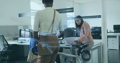 Colleagues Collaborating Beside Bicycle in Modern Open-Plan Office Discussing Documents