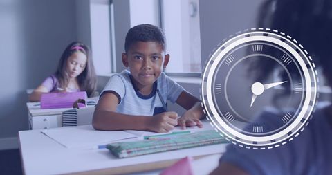 Boy Smiling at Desk in Classroom with Clock Overlay