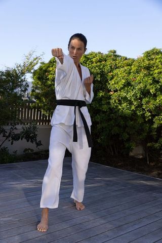 Martial artist practicing karate outdoors on wooden deck
