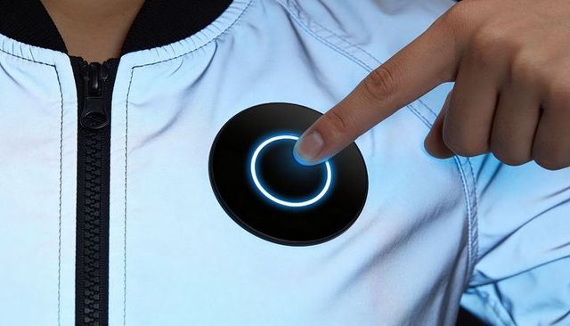 Pressing wearable smart sensor on chest-mounted led ring patch on light zip-up jacket