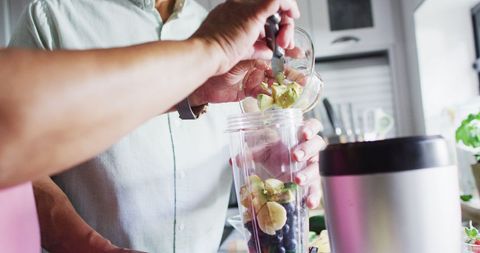 Senior Couple Making Fresh Smoothie in Modern Kitchen