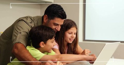 Father guiding children on laptop for home learning and digital skills