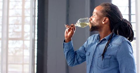 Man Elegantly Tasting White Wine in Contemporary Setting - Download Free Stock Images Pikwizard.com