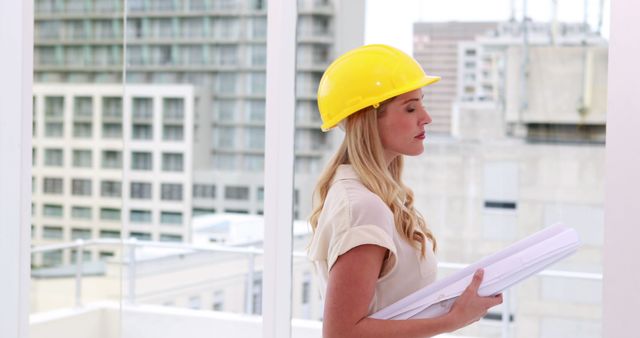 Female Architect in Hard Hat Holding Construction Plans - Download Free Stock Images Pikwizard.com
