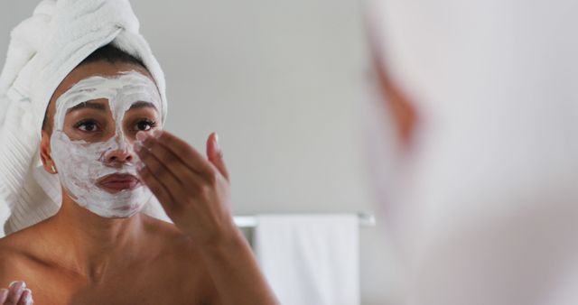 Woman applying skincare face mask in the bathroom mirror - Download Free Stock Images Pikwizard.com