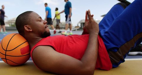 Basketball Player Relaxing on Court Using Smartphone