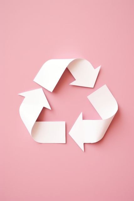 Paper recycling symbol with white arrows and pink background promoting environmental awareness and sustainability initiatives. Useful for websites, campaigns, eco-friendly products, and educational materials.