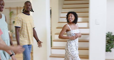 Group of friends entering modern home smiling