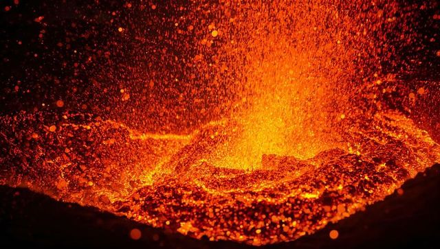 Fiery molten lava bubbling within a volcanic vent at night