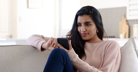 Woman Engaging with Smartphone in Modern Cozy Living Room