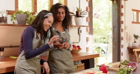 Diverse Women Enjoy Cooking Together in Rustic Kitchen