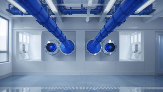 Blue industrial ductwork with circular intake fans in clean mechanical room, hvac systems