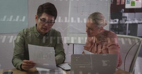 Business professionals analyzing data charts in modern boardroom