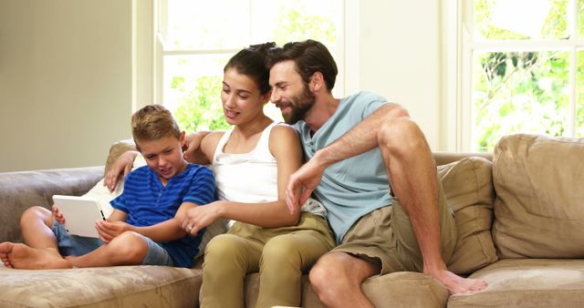 Happy Family Sitting on Couch Using Digital Tablet - Download Free Stock Images Pikwizard.com