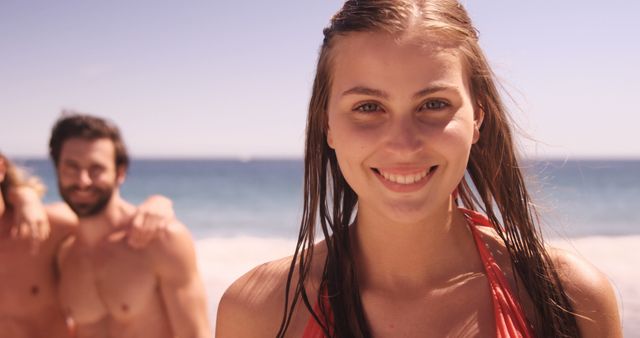 Young Woman Smiling on Beach, Friends in Background - Download Free Stock Images Pikwizard.com