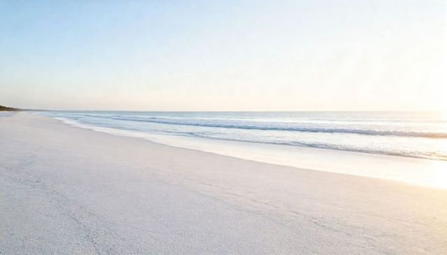 Casting low sun over empty beach with wet sand glare, tranquil coastline at sunrise